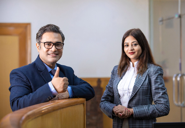 Professional making a thumbs up sign while posing for a picture with his colleague